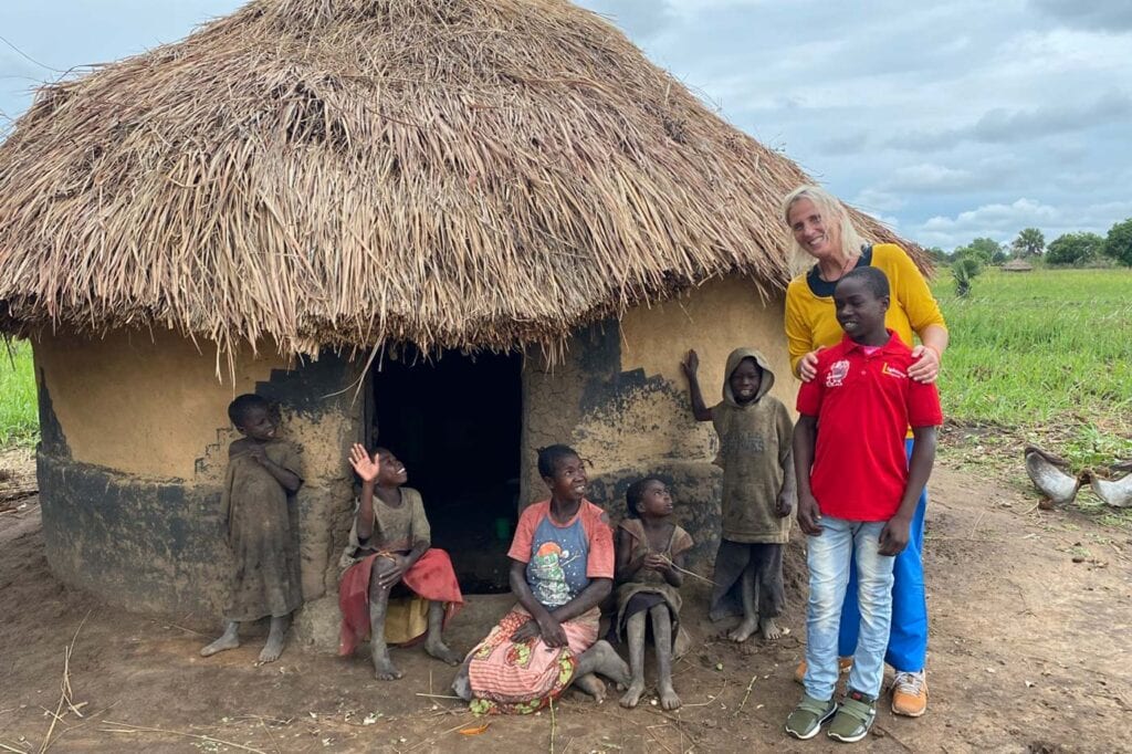 Kinder und Jugendliche in Afrika vor einem Lehmhaus